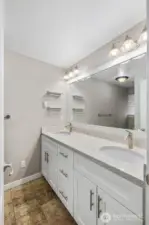 Bathroom with double vanity, large mirror, modern lighting, and plenty of counter space for daily routines.