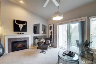 Living room with gas fireplace and vaulted ceiling.