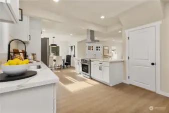 Here is another view of large open kitchen looking toward front door and great room.  The home is filled with LVP flooring throughout to make it easy to clean and keep up.  This is door to lower level apartment or second kitchen bonus room downstairs