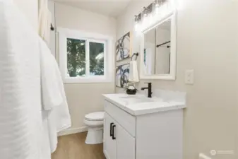 Second view of new bath on main level with cute vanity quartz counters modern lighting and oil rubbed bronze fixtures