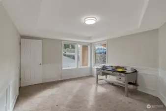 Main level bedroom, light and bright with wainscotting surround and detailed ceiling.