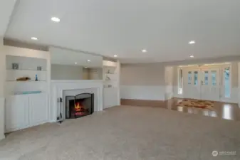 Living room complete with a wood burning fireplace, built ins with plenty of storage and space for decor. Wainscoting surrounds the area giving it a warm, cozy feel with elegance.