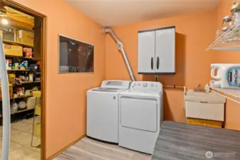 Oversized laundry room with adjacent storage room provides ample storage space.