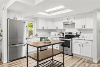 The kitchen feautures stainless steel appliances, full-height tile backsplash and quartz countertops.