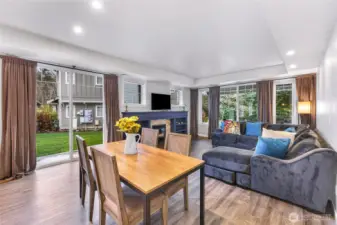 Light filled living and dining area with a cozy gas fireplace and easy access to the grassy backyard.