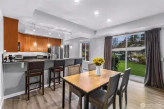 Dining area with oversized windows and a slider that opens to the lawn, filling the space with natural light.