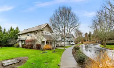 A wide, tree lined street leads you into this serene neighborhood with lush green space and sidewalks throughout.
