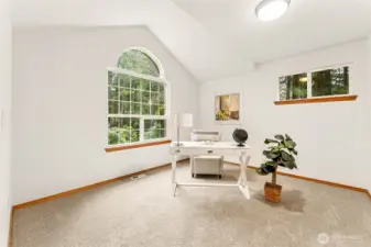 Light-filled vaulted den just off the entryway, offering peaceful views of the surrounding greenery.