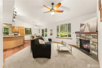 Enjoy comfort and connection in this airy living room, complete with ceiling fan and a warm stone-wrapped fireplace.