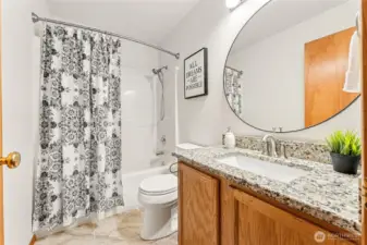 Classic hall bath with modern updates, including slab vanity and elegant tile floors.