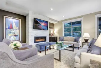 Sophisticated family room with linier gas fireplace and stone accent surround. 60" Smart, flat screen TV stays with the home. Storage cabinets with leathered granite countertop.