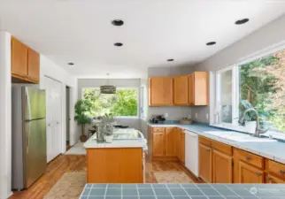 Side view of kitchen with dining area and recess lighting.