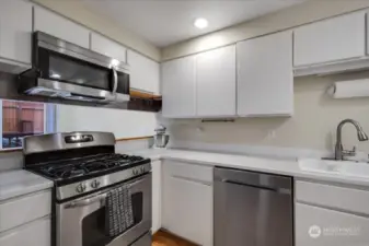 Kitchen features a gas stove and stainless appliances.