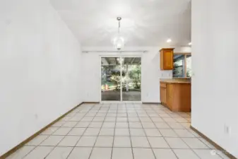 Dining space with sliding glass door that opens up to a covered patio in need of some repair.