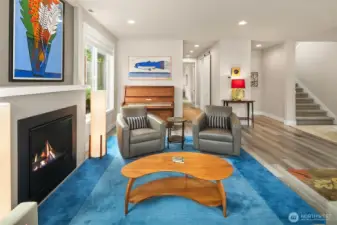 Pristine LVP flooring and a cozy gas fireplace nicely accent this elegant space. Note the stairway to the upper floor is extra wide.