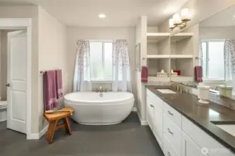 Beautiful primary bath with vessel soaking tub and water closet.