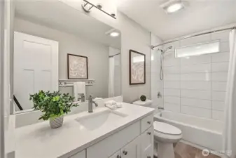 The main floor full bathroom is completely remodeled with Quartz countertop, undermount sink, soft close cabinets and drawers, new fixtures and tiled tub surround.