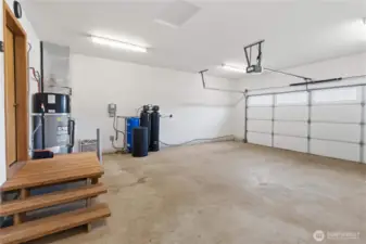 Two car garage with man door to the side of the home.