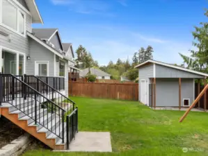 Stairs from Deck out to the fenced Backyard with Shop +Dog kennel.