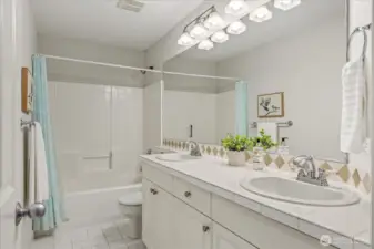 Hallway Guest Bath with dual vanities and ample storage.