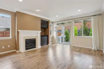 living room w/ gas fireplace w/ custom wood mantle and tile below.