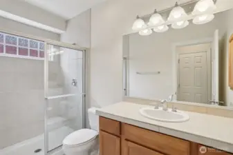 Primary bathroom with tile shower and window above shower provides abundance of natural light.