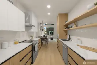 The kitchen features stainless steel appliances, built-in shelving, and a plethora of cabinetry for storage
