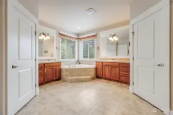 The luxurious primary bathroom boasts separate dual vanities, a soaking tub, and a separate shower.