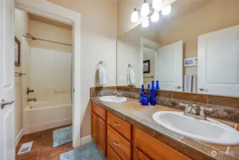 Guest bathroom is tastefully designed with modern fixtures and a shower/tub combo.