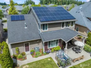 This aerial view showcases the home's solar panels and charming backyard, highlighting its eco-friendly features and ample outdoor space.