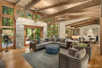 Open concept great room with vaulted wood ceilings, exposed beams, walls of windows and access to the entertainment patio