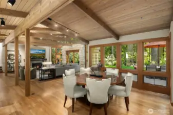 Open concept great room with vaulted wood ceilings, exposed beams, walls of windows and access to the entertainment patio