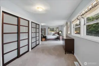 Oversized primary bedroom with double closets and views of the backyard.