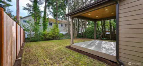 The covered deck seamlessly blends comfort and style, perfect for entertaining or relaxation.