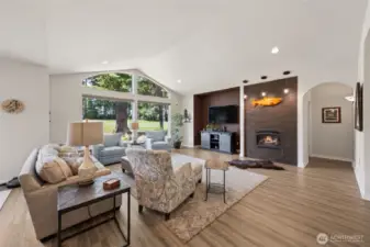 Vaulted great room overlooking the fairway -- cozy propane fireplace, large picture windows, and LVP flooring.