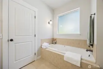 Deep soaking tub with tile surround.