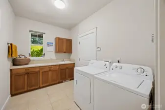 Huge utility room has plenty of storage and includes a utility sink.