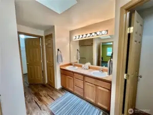 Primary double vanities, toilet room to the right and walk-in closet to the left.