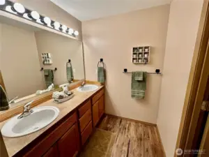 Hall bath offers dual vanities and can be closed off from shower and toilet room.