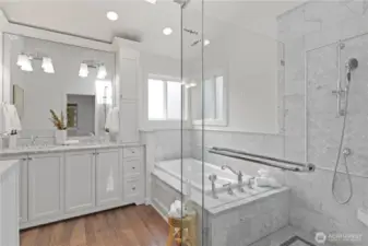 Chic, beautifully finished spa-like bathroom. Huge step in shower, built-in soaking tub, and double vanity with countertop apothecary-style cabinets. Crown molding, gorgeous herringbone pattern wraps around the bathtub and shower walls, plus shampoo niches in the shower and at the tub. Vaulted ceilings and a skylight make this room a wonderful place to escape to.