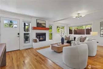 Open concept main floor plan with cozy gas fireplace and wood mantle.