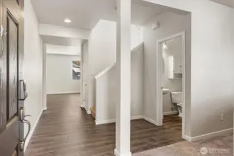 Welcoming entry showcases laminate floors, a useful flex room, and a convenient main-level guest bath