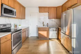 Fully remodeled kitchen with brand new stainless steel appliances, quartz countertops, and continuous quartz backsplash.