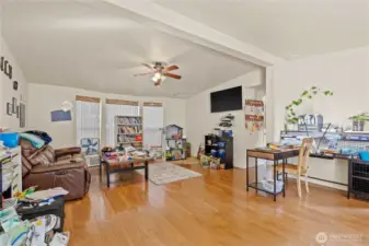 Living Room w/Vaulted Ceilings, Bay Window and Ceiling Fan. Laminate Floors. Corner is missing Flooring as there was a FP there originally and it was removed.