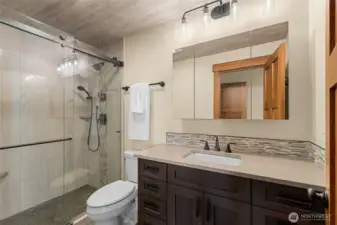 Primary bathroom, tiled shower and upgraded cabinetry and granite counters