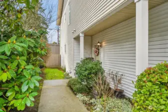 Walkway surrounded by lush greenery, leading to a welcoming front entrance.