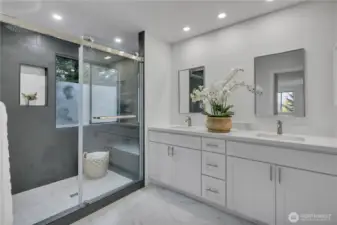 Gorgeous primary bathroom w/double vanity, quartz counters & walk-in frameless glass shower. (water closet is opposite the shower)