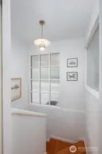 Stairwell to lower level is light filled and has original fir stair treads.