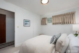 Lower level bedroom with door to hall, close to exterior entrance.