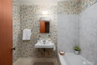 Lower level full bathroom has been updated to include ventilation, new plaster & new toilet.  The wallpaper is too cute to remove!